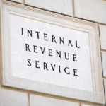 Sign on a stone wall displaying the text "INTERNAL REVENUE SERVICE" in bold, uppercase letters.