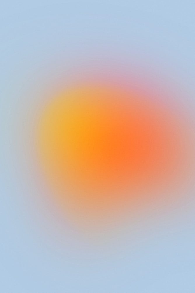 Soft gradient background with orange, yellow, and pink hues blending into a light blue backdrop.