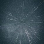Starry night sky with white streaks radiating outward, creating a sense of depth and motion against a dark background.