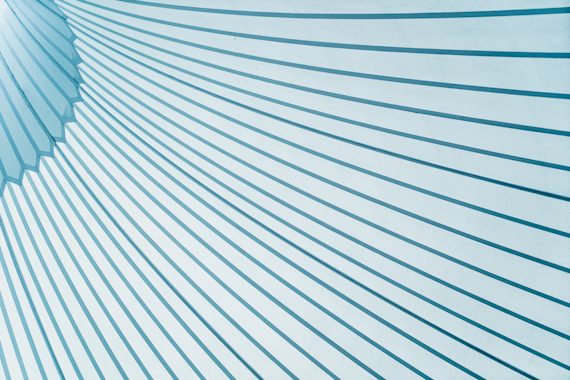 Diagonal blue and white lines create a geometric pattern on a light background, forming a dynamic visual effect.
