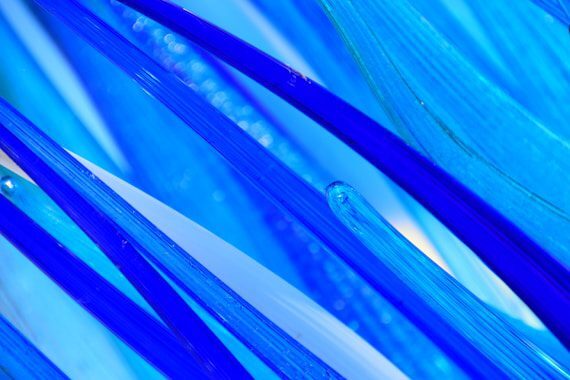 Blue glass strands in varying shades of blue, with some translucent areas creating depth and texture.