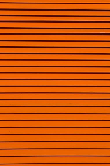 Horizontal lines of varying thickness in a bright orange color, creating a textured, striped pattern.