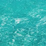 Turquoise water with ripples reflecting sunlight, creating a shimmering effect on the surface.