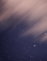 Starry night sky with scattered stars against a dark blue background, partially obscured by wispy clouds.