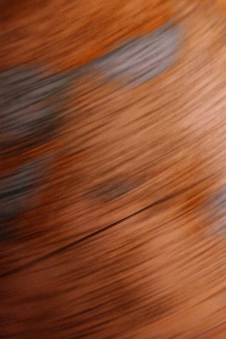 Abstract swirls of warm orange and muted blue tones, creating a dynamic, blurred texture.